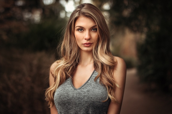 Woman with long blonde hair in a grey top