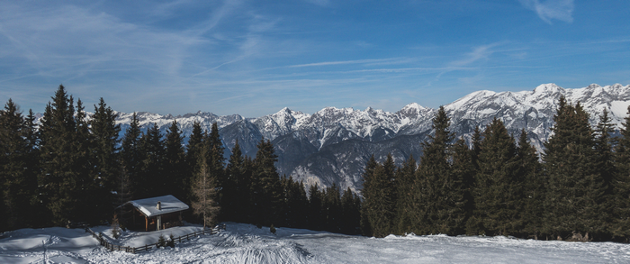 Snowy mountain landscape with a cabin and forest