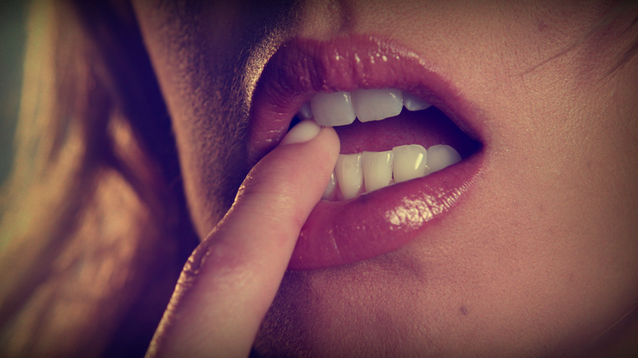 Woman with finger in mouth and juicy lips