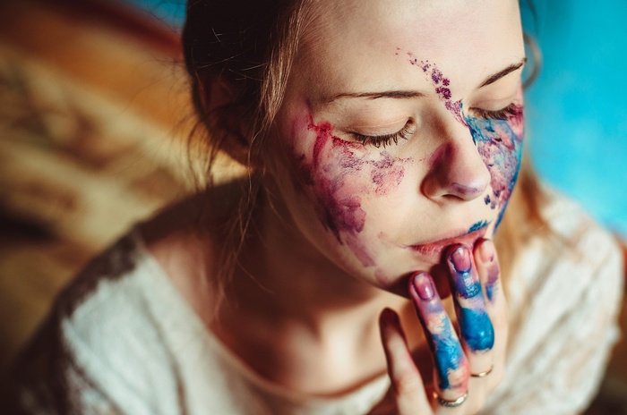 Woman with paint on face and fingers