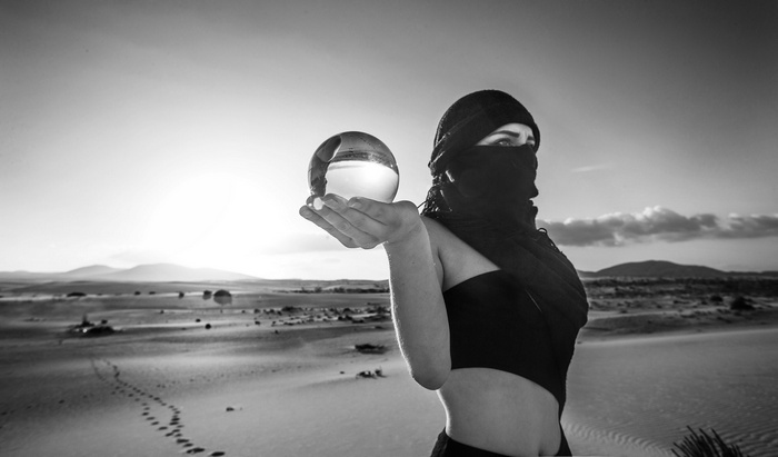 Woman in desert holding crystal ball