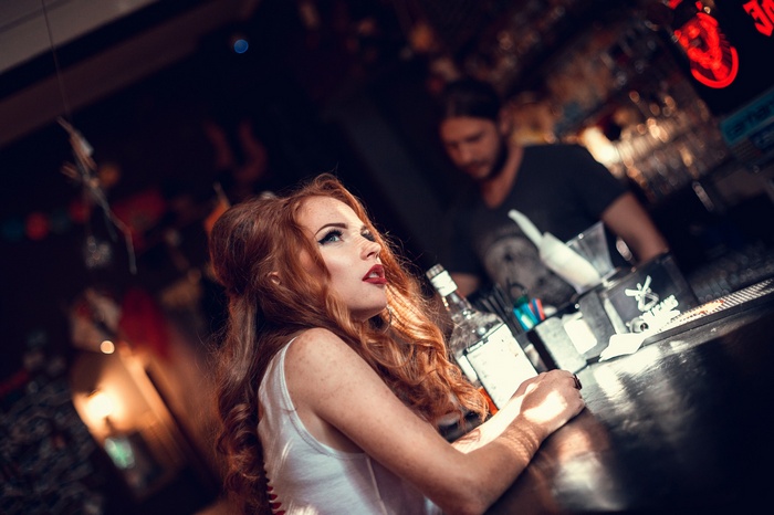 Redhead woman at a bar with a bartender