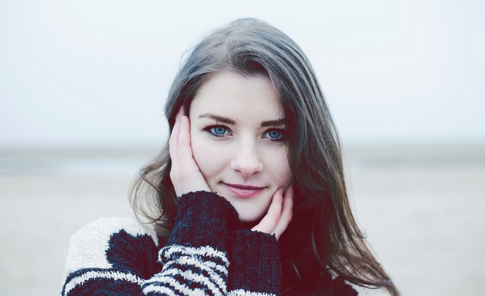 Woman with blue eyes wearing a sweater outdoors