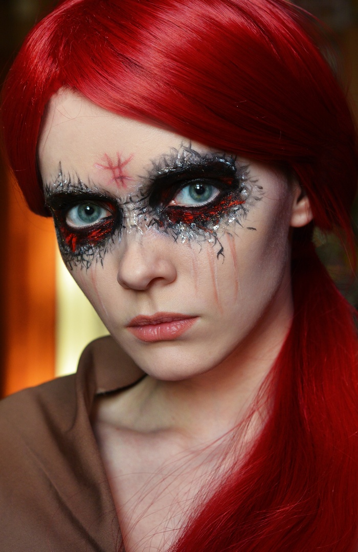 Woman with red hair and dramatic makeup