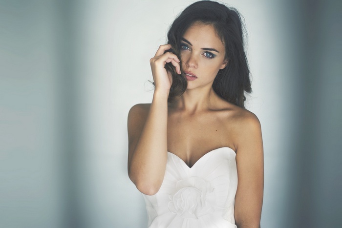 Woman with blue eyes in a white strapless dress