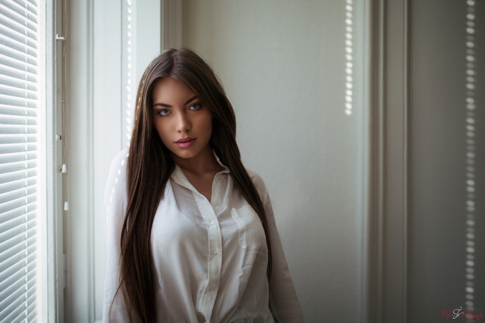 Woman with long brown hair by window