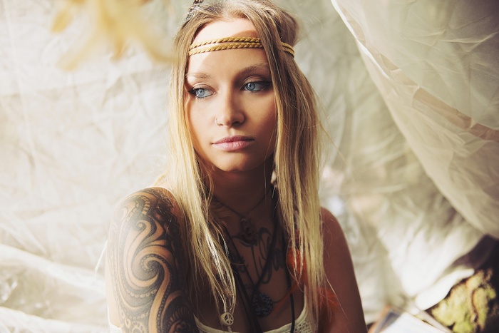Woman with blonde hair and tattoos wearing a headband