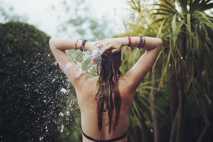 Woman showering outdoors with water splashing
