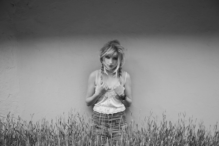 Woman with braids leaning against a wall