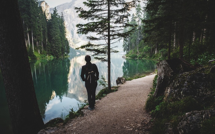 Woman with backpack by a lake in the mountains