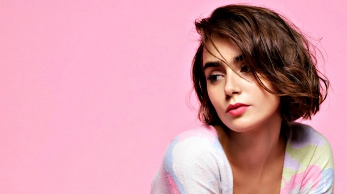 Lily Collins with short brown hair and pink background