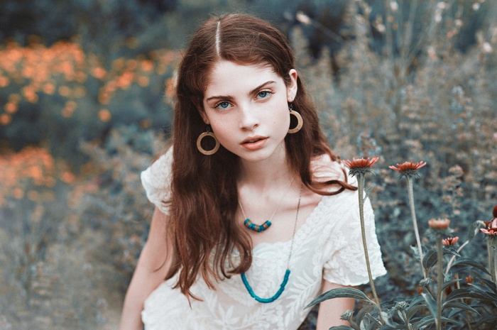 Woman with blue eyes and hoop earrings in a field