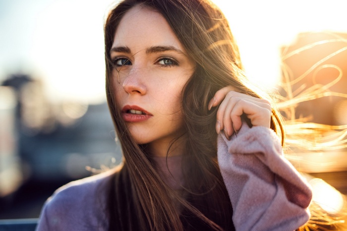 Woman with long brown hair in sunlight