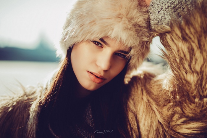 Model wearing fur hat and coat outdoors