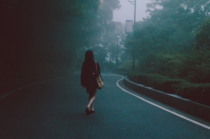Woman walking on a misty road