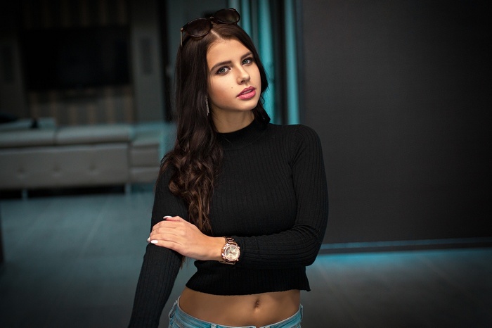 Woman with sunglasses on head wearing black top and jeans