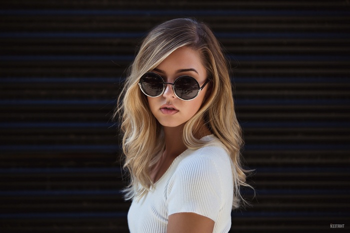 Woman wearing sunglasses and white top