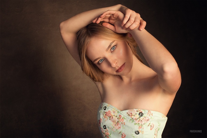 Woman with blonde hair and blue eyes, arms up