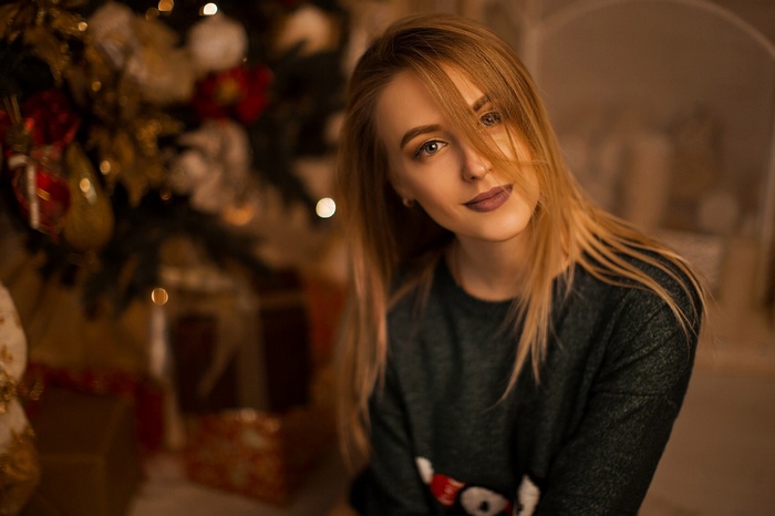 Woman with blonde hair in front of Christmas tree