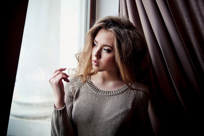 Woman in sweater by the window