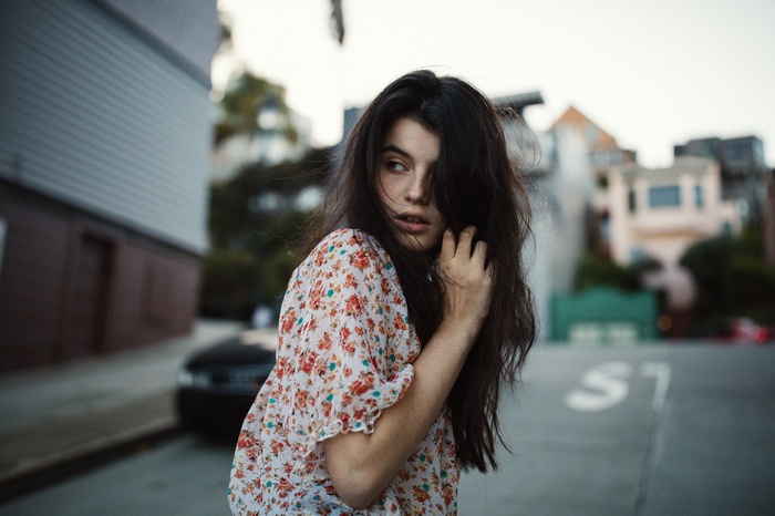 Woman with dark hair in floral shirt on street