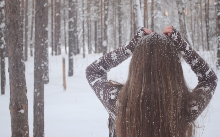 Woman with long hair in a snowy forest