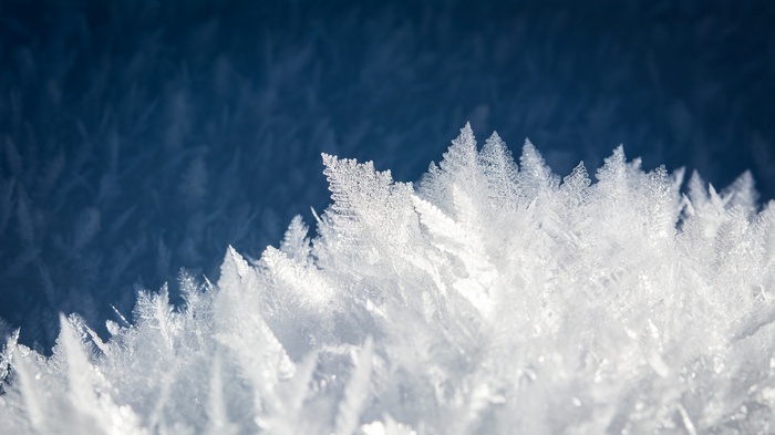 Close-up of frost crystals on a dark blue background