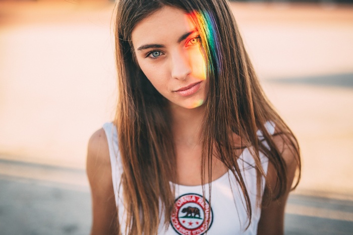 Woman with rainbow light on face