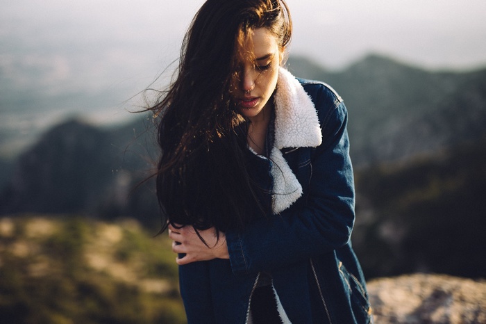 Woman with dark hair wearing a denim jacket outdoors