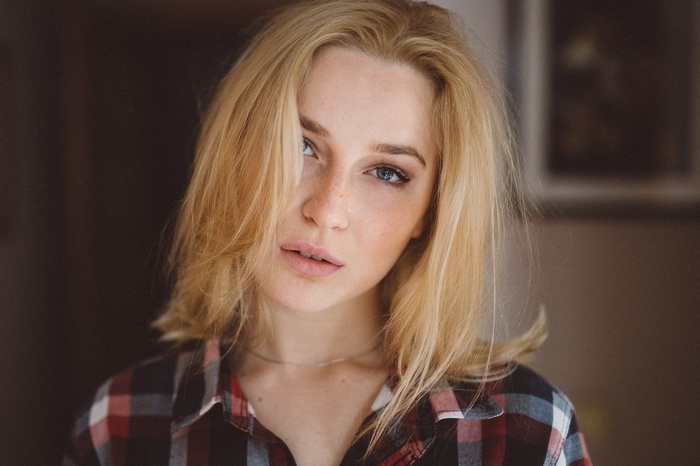 Woman with blonde hair and freckles wearing a plaid shirt