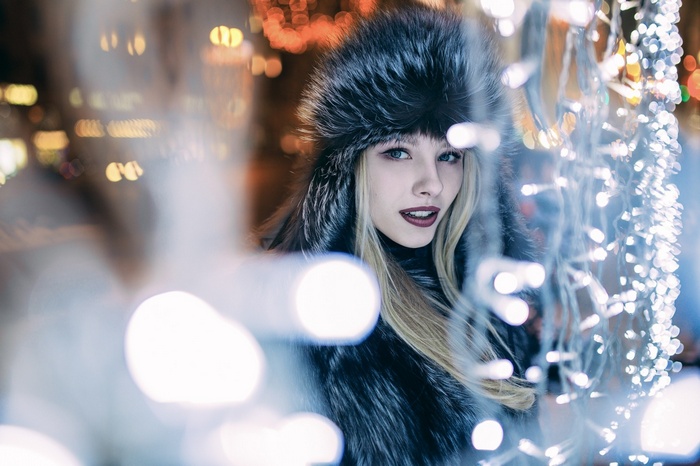 Alice Tarasenko wearing a fur coat with Christmas lights