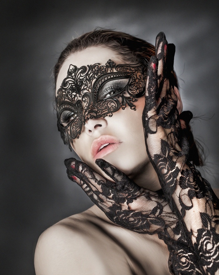 Woman wearing a black lace mask and gloves