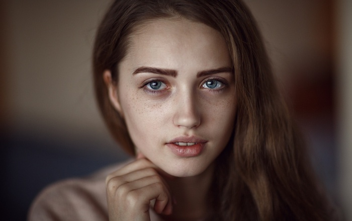 Portrait of a young woman with freckles and blue eyes