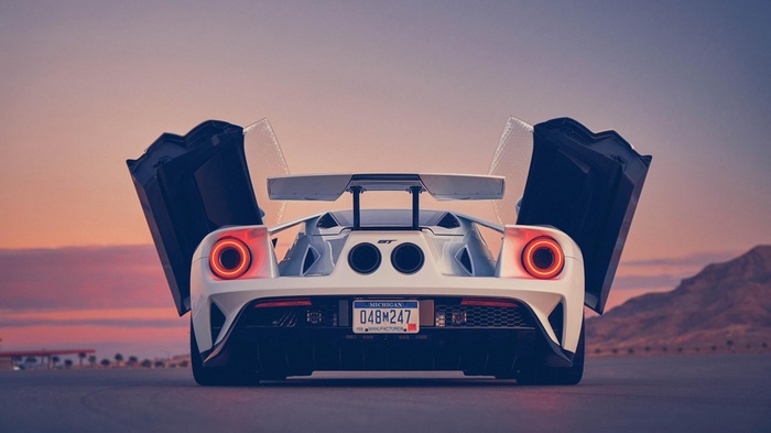 White Ford GT with butterfly doors open at sunset