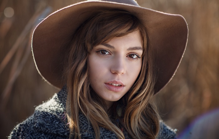 Woman wearing a hat and coat, looking at viewer