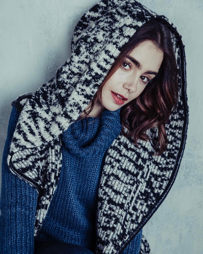 Lily Collins wearing a blue sweater and patterned scarf