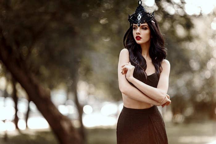 Woman with black hair and crown in a park