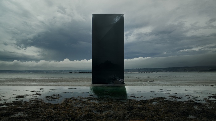 Monolith on a beach with stormy clouds