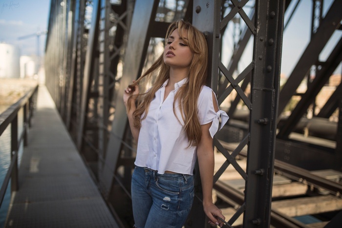 Woman in white shirt and jeans on a bridge