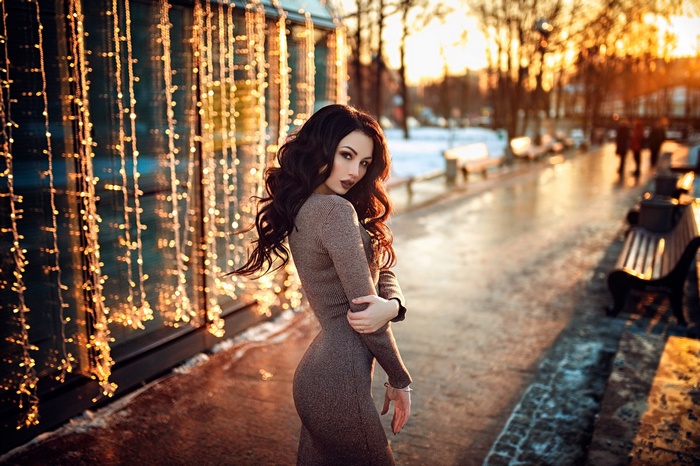 Woman in dress with string lights and sunset