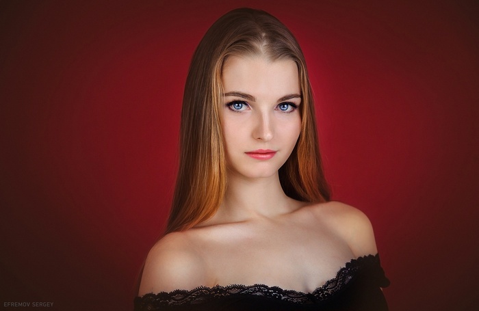Woman with blonde hair and blue eyes on red background