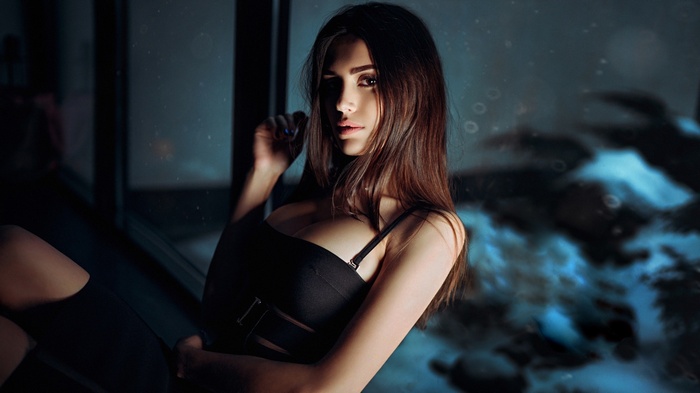 Woman in black dress sitting by window