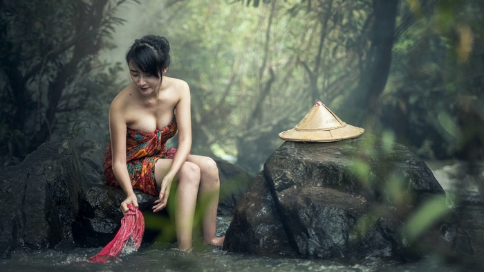 Woman washing clothes in a river