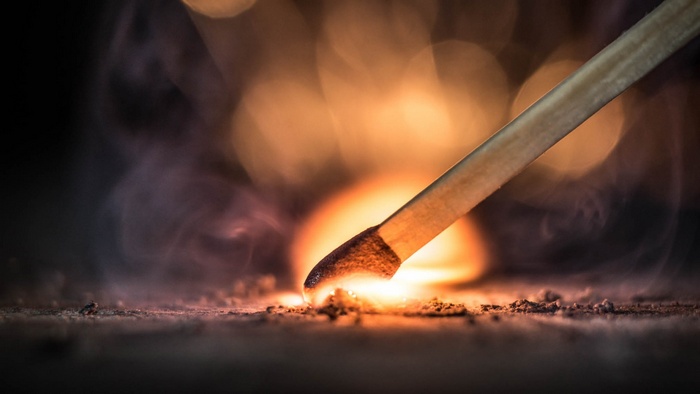 Burning matchstick igniting on a surface