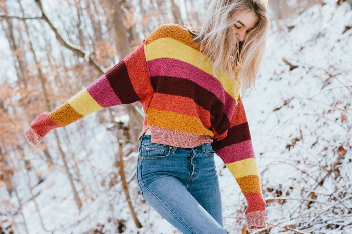 Woman in striped sweater and jeans in snow