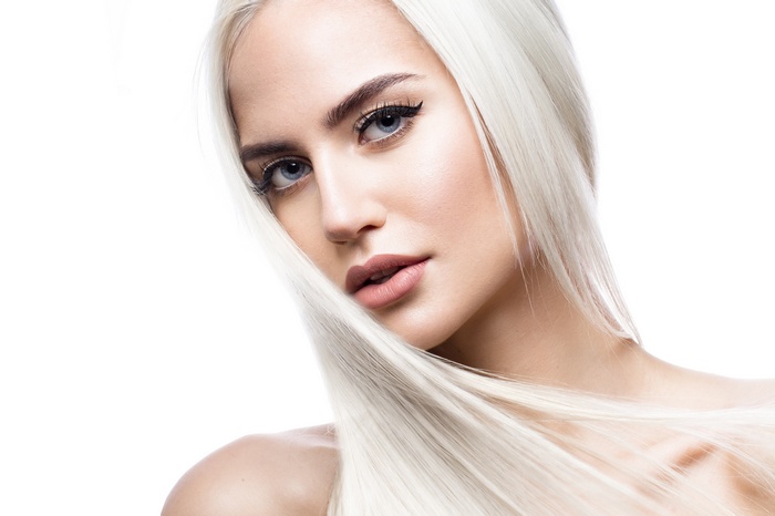 Woman with long blonde hair and makeup