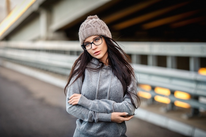 Brunette woman with glasses wearing a beanie and hoodie