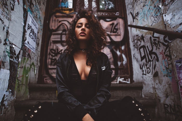 Woman with curly hair sitting on stairs