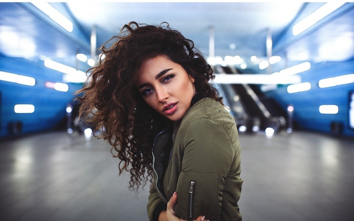 Woman with curly hair in a subway station