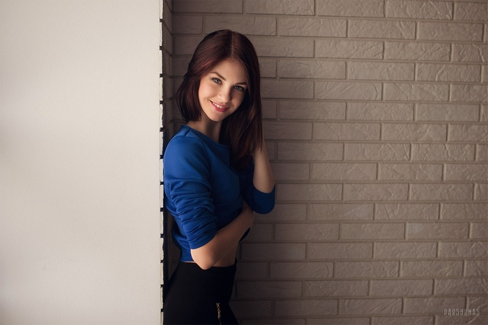 Elena Paramonova posing against a brick wall